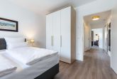 Schlafzimmer mit Boxspringbett, Kleiderschrank und Blick zum