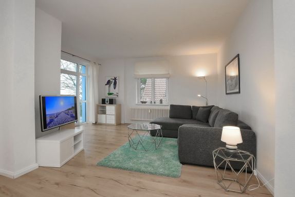 Wohnzimmer mit Schlafcouch und TV