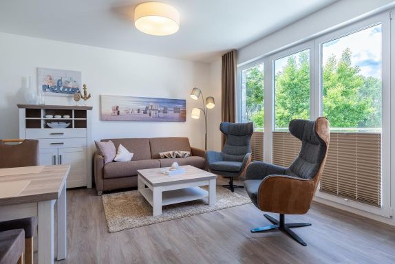 Wohn-/Essbereich mit Doppelschlafcouch, Couchtisch und Sesse