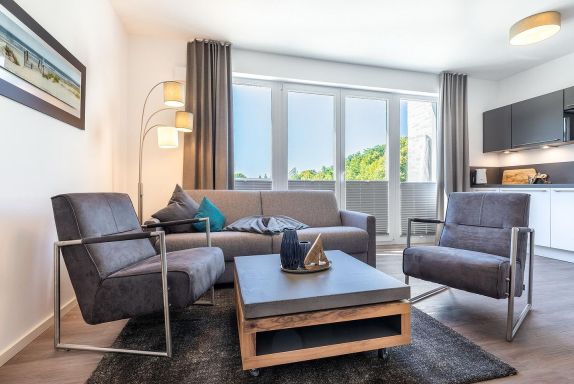 Wohn-/Essbereich mit Sitzgelegenheiten und Zugang zum Balkon