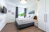 Schlafzimmer mit Boxspringbett, TV und Kleiderschrank