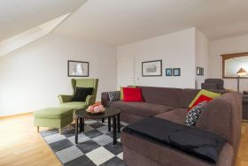 Wohnzimmer mit Couch und Sessel