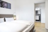 Schlafzimmer mit Doppelbett und Zugang zum Badezimmer
