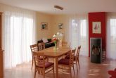Wohnzimmer mit Esstisch, Ecksofa, Kamin und TerrassentÃ¼ren 