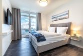 Schlafzimmer mit Boxspringbett und Flatscreen-TV