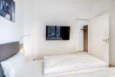 Schlafzimmer mit Doppelbett und Flatscreen TV