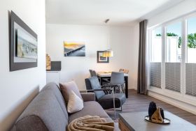 Wohn-/Essbereich mit Doppelschlafcouch und Zugang zur Dachte