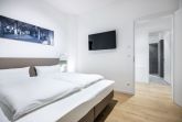 Schlafzimmer mit Doppelbett und TV