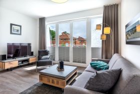 Wohn-/Essbereich mit Doppelschlafcouch, Couchtisch, TV und Z