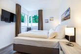 Schlafzimmer mit Boxspringbett und TV
