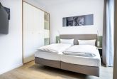 Schlafzimmer mit Doppelbett und Kleiderschrank