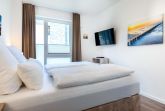 Schlafzimmer mit Boxspringbett und TV