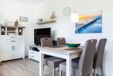 Wohn-/Essbereich mit Tisch, Sitzgelegenheiten und TV