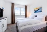 Schlafzimmer mit Doppelbett, Fenster und TV