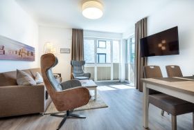 Wohn-/Essbereich mit TV und Zugang zur Terrasse