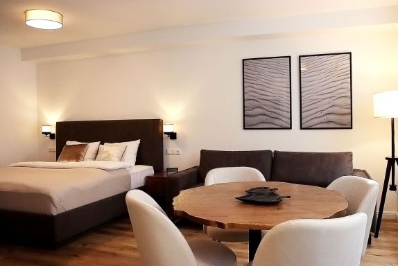 Wohnzimmer mit Bett und Essbereich
