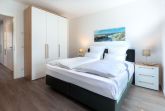 Schlafzimmer mit Boxspringbett und Kleiderschrank