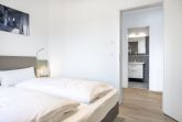 Schlafzimmer mit Doppelbett und Zugang zum Badezimmer