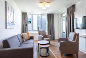 Wohn-/Essbereich mit Doppelschlafcouch und Zugang zur Loggia