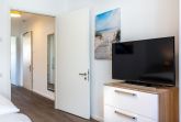 Schlafzimmer mit TV und Zugang zum Flur