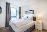 Schlafzimmer mit Doppelbett und TV