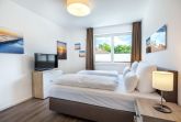 Schlafzimmer mit Boxspringbett (1,80 x 2,00 m) und TV