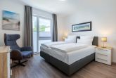 Schlafzimmer mit Boxspringbett (1,80 x 2,00 m) und Sessel