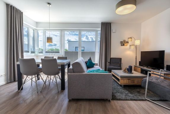 Wohnbereich mit TV, Sitzgelegenheiten und Zugang zur Dachter