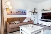 Wohn-/Essbereich mit Doppelschlafcouch, Couchtisch und TV